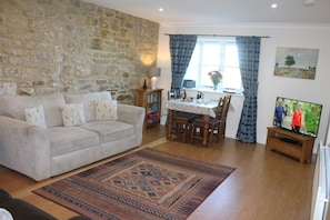 Relax in this inviting living room with a sofa, coffee table, and dining area.