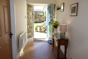 Enter a serene outdoor space from this cozy hallway, featuring a patio with a table and chairs.