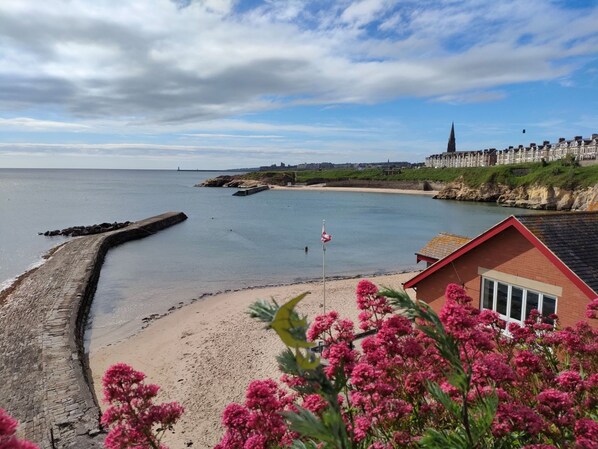 Stunning coastal views from the beachfront building with a red roof and flagpole.