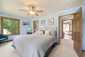 Ein Schlafzimmer mit Bett, Deckenventilator, Fenster und Tür.
