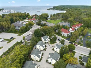 Ein Luftbild eines Wohngebiets mit Häusern, einem Yachthafen und einer bewaldeten Landschaft.