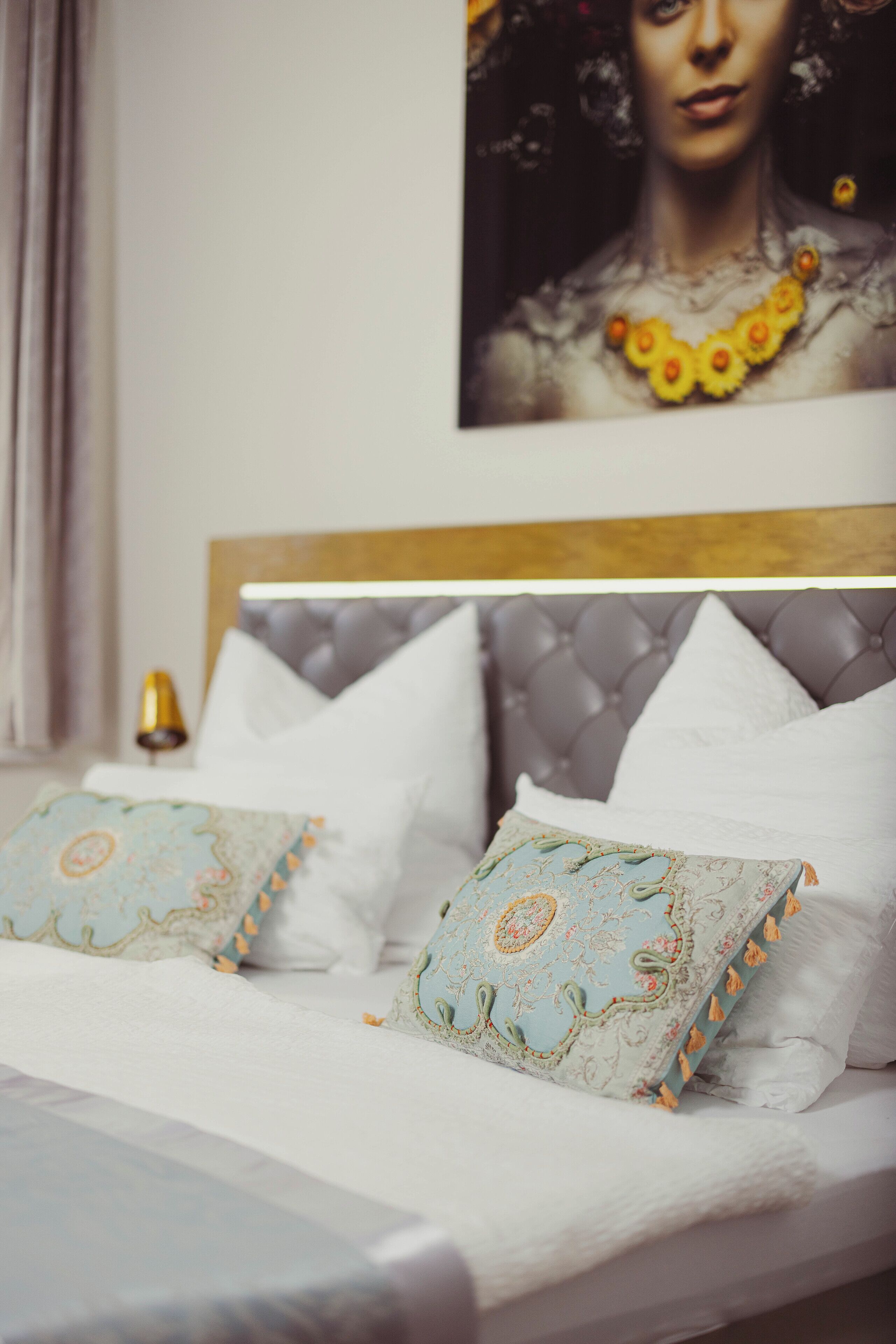 A neatly made bed with patterned pillows and a headboard with a tufted design.