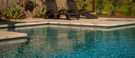 Una piscina al aire libre de temporada, sombrillas