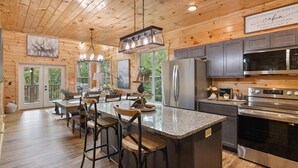 L’intérieur de la cabine est doté d’un plafond en bois, d’un îlot central avec des tabourets de bar, d’une cuisine équipée d’appareils électroménagers en acier inoxydable et de grandes fenêtres.