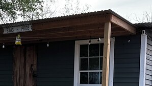 Eine rustikale Holzhütte mit Veranda, einer Holztür und einem Fenster.