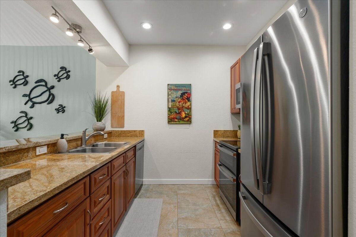 A kitchen with granite countertops, stainless steel appliances, wooden cabinets, and a decorative wall piece.