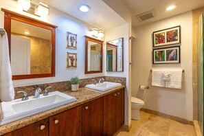 A bathroom with two sinks, a toilet, and a shower. - Grand Champions 40 2 Bedroom Condo (Kihei)