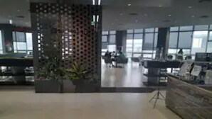 Un'ampia hall dall'arredamento moderno, con reception, area salotto e ampie finestre che lasciano entrare la luce naturale.