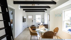 Um interior moderno com área de jantar, escada e vista para o exterior.