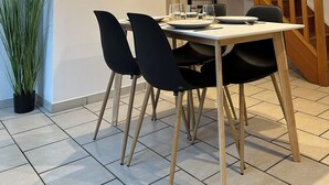 Ein Essbereich mit einer Holztreppe, einem Topfpflanzen und einem Tisch für vier Personen.