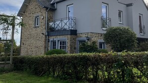 A two-story house with a stone facade and a grey roof.