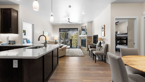 A modern kitchen with a central island, dark cabinetry, and pendant lighting. - Clearwater Lofts #302, Building 3 By Summit County Mountain Retreats (Keystone)