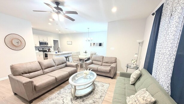 A modern living room with a sofa set, a coffee table, and a dining area with a table and chairs. - Purple Paws Pad for LSU Tigers on the Go -  CL5610 (Baton Rouge)