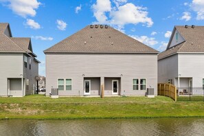 A row of two-story houses with a flat roof, a front garage, and a small front yard.