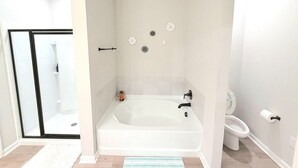 A bathroom with a bathtub, toilet, and shower area. - Purple Paws Pad for LSU Tigers on the Go -  CL5610 (Baton Rouge)
