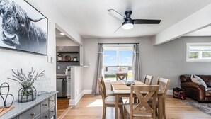 A modern kitchen with a dining area, a ceiling fan, and a view through the window. - Experience Cheyenne in a cozy home, close to Downtown, Medical Center and CFD.  (Cheyenne)