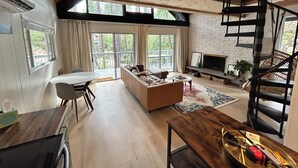 A spacious living area with a wooden ceiling, a sofa set, a dining table, and a staircase. - Silver King Cabin. 6,200 ft of elevation. 10 minutes from downtown Prescott.  (Prescott)