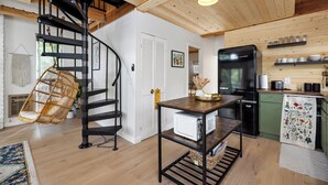 A modern kitchen with a black refrigerator, wooden cabinets, and a hanging chair. - Silver King Cabin. 6,200 ft of elevation. 10 minutes from downtown Prescott.  (Prescott)