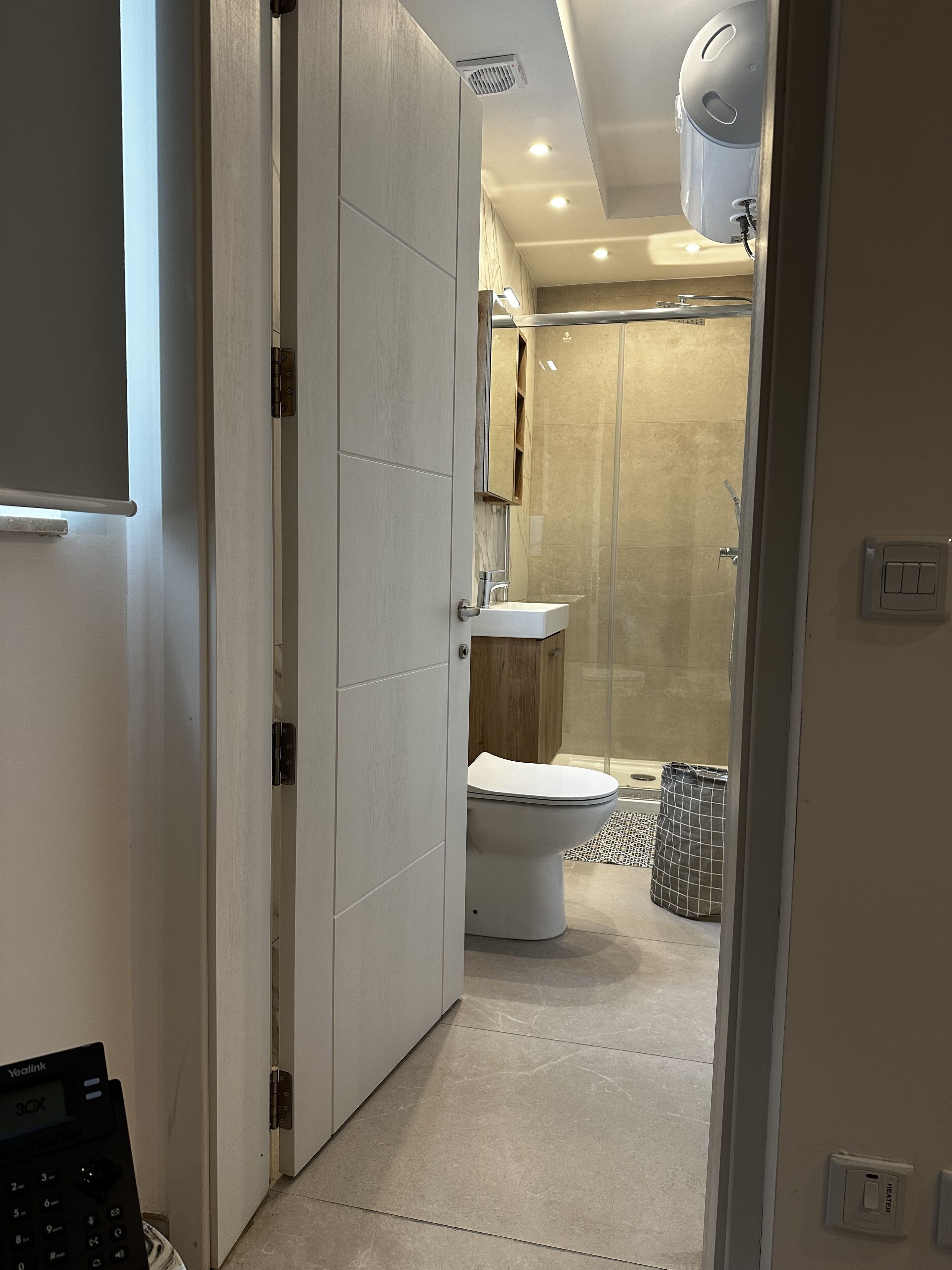 A modern bathroom with a toilet, sink, and shower area.