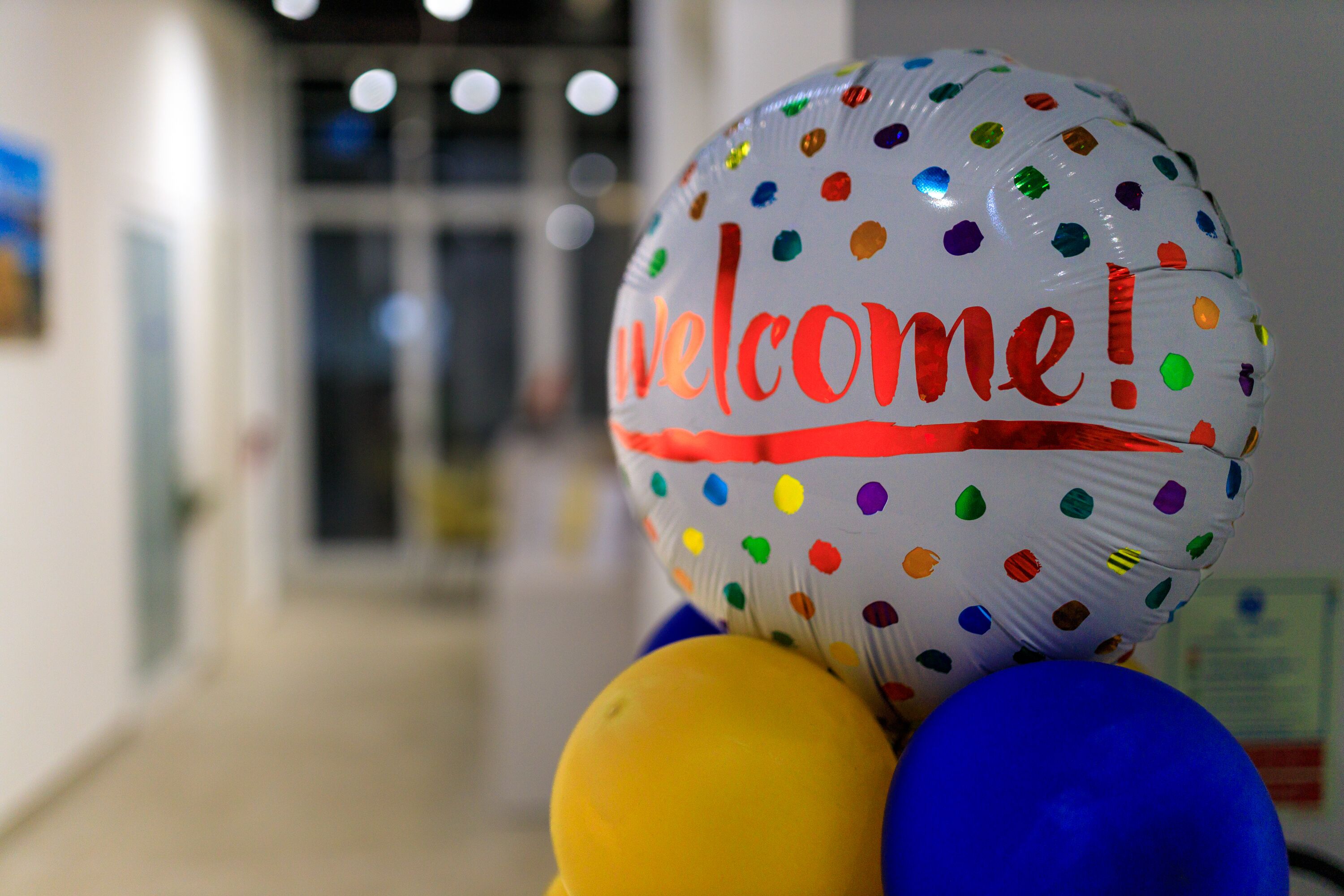 A balloon with "welcome!" written on it, surrounded by other balloons.