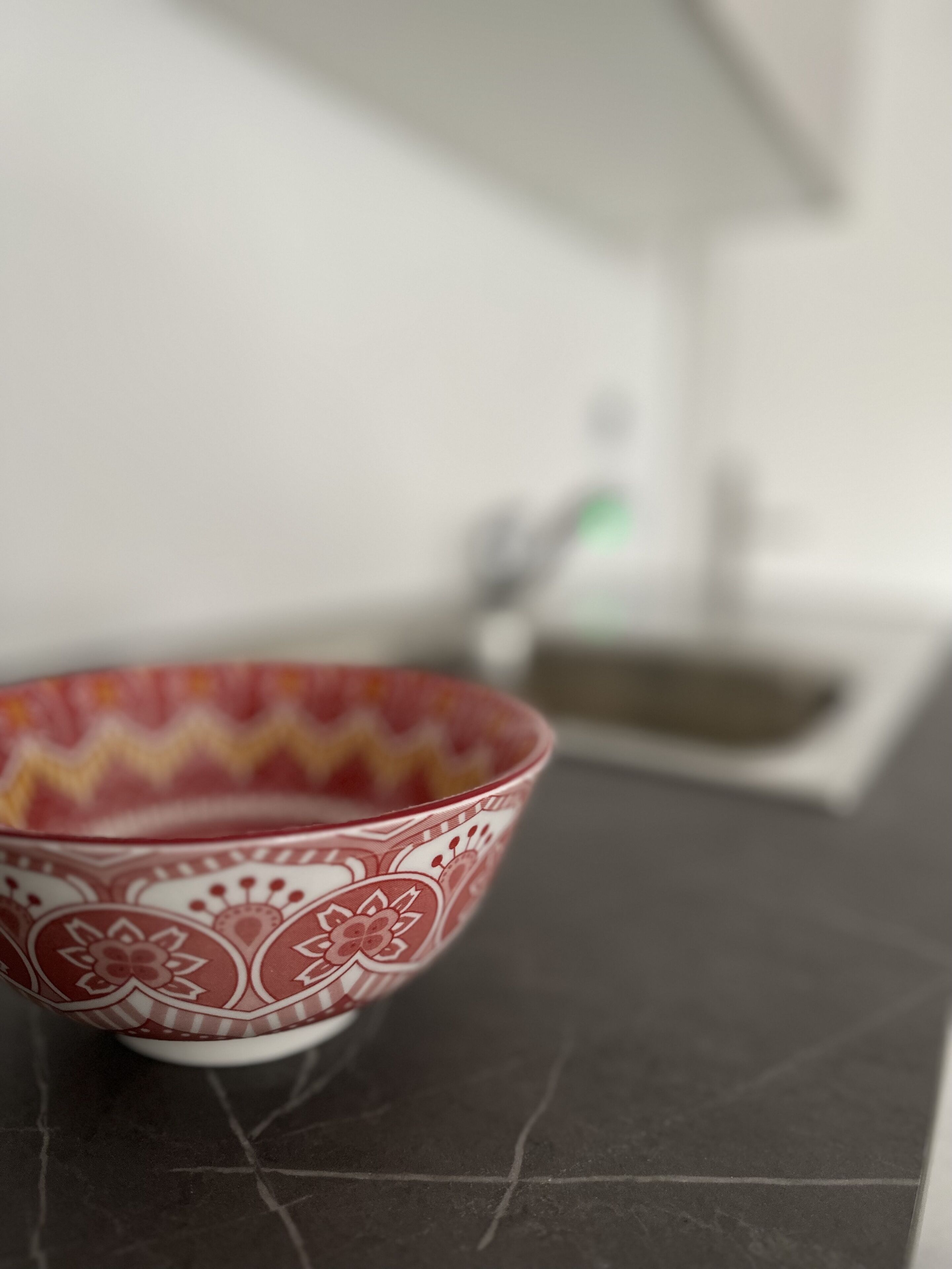 A bowl with a floral pattern on a dark countertop.