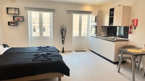 Un dormitorio con cama, una kitchenette pequeña y un comedor.