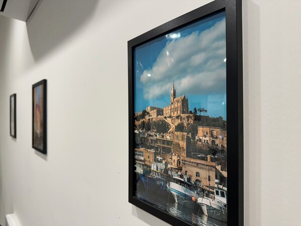 A framed photograph of a coastal town with a prominent church on a hill, a harbor with boats, and a clear sky.