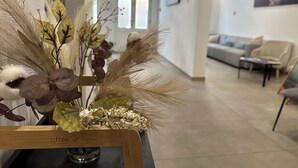 Zona de recepción con una mesa de madera mostrando un arreglo floral.