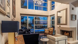 A spacious living room with a modern fireplace, large windows, and a chandelier. - Luxury Villa Duchess with Pool (Crikvenica)