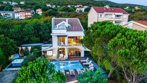 A two-story house with a swimming pool, surrounded by trees and other houses. - Luxury Villa Duchess with Pool (Crikvenica)