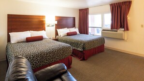 A hotel room with two beds, a leather couch, and an air conditioning unit. - Hot Springs Hills Inn (Hot Springs)