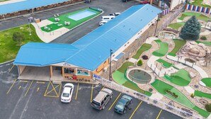 An aerial view of a building with a blue roof, a swimming pool, and a miniature golf course. - Hot Springs Hills Inn (Hot Springs)