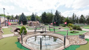 A miniature golf course with a water hazard, green artificial turf, and various obstacles. - Hot Springs Hills Inn (Hot Springs)