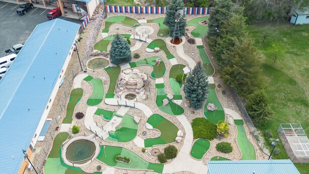 A miniature golf course with a winding layout, a windmill, and a pond. - Hot Springs Hills Inn (Hot Springs)