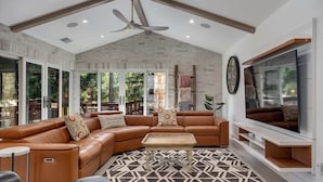 A modern living room with a sectional sofa, a coffee table, a TV, and a patterned rug. - The Dragonfly - Healdsburg with Pool, Hot Tub and Tastings Included (Healdsburg)