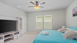 A bedroom with a bed, a TV, a ceiling fan, and a window with blinds. - Stay with Style and Cheer for the Tigers -  CB1029 (Baton Rouge)