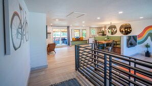 Een ruime woonkamer met een trap, een eethoek en een keuken met modern interieur.