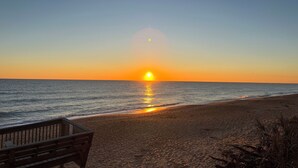 A beach with a wooden bench and a clear view of the sunset over the ocean. - The BEST View at Cinnamon Beach- Largest Ocean Unit, Sunrise and Sunset! (Palm Coast)