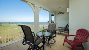 A balcony with a view of the ocean, furnished with chairs and a table. - The BEST View at Cinnamon Beach- Largest Ocean Unit, Sunrise and Sunset! (Palm Coast)