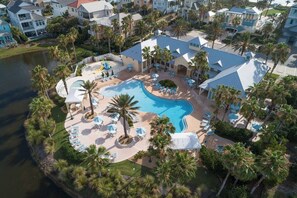 An aerial view of a resort with a large swimming pool surrounded by palm trees and lounge chairs. - The BEST View at Cinnamon Beach- Largest Ocean Unit, Sunrise and Sunset! (Palm Coast)