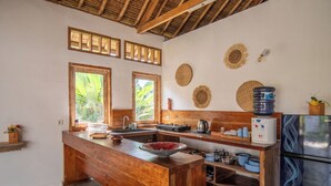 A kitchen with wooden countertops, a central island, and a refrigerator.