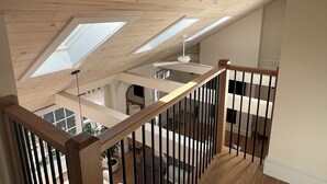 Ein Holzinnenraum mit Oberlichtern, einer Treppe und Blick ins Freie.