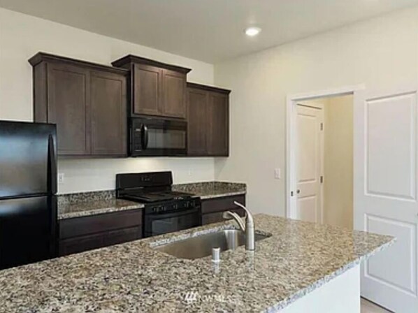 Enjoy cooking in this well-equipped kitchen with an oven, microwave, and stainless steel sink.