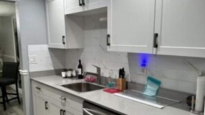 A modern kitchen with white cabinets, a stainless steel sink, and a dishwasher. - On the beautiful lake, it is close to the airport, malls,restaurants ,beach etc. (Lauderhill)