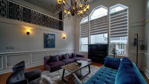 A living room with a sectional sofa, a purple couch, a coffee table, and a fireplace.