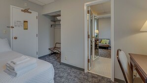A hotel room with a bed, a chair, a desk, and a mirror. - Cozy Suite in a Revamped Dorm Room! (Nashville)