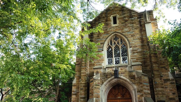 A stone church with a large wooden door and arched windows.