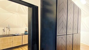 A modern kitchen with wooden cabinets, a black countertop, and a view of the dining area.
