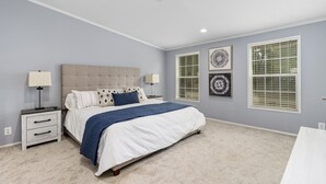 Un dormitorio con cama, mesitas de noche y decoración en la pared.