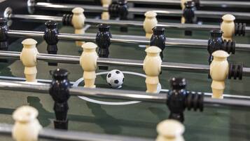 A close-up of a foosball table with black and white player figures.